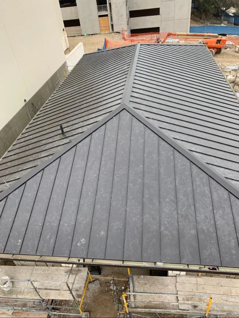 Commercial metal roof construction with crane equipment in Sullivan